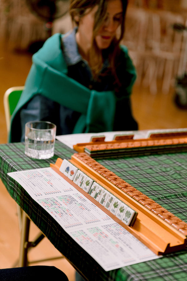A leather card holder and rack beside the mahjong card