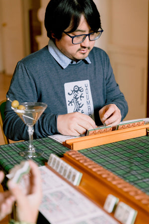 A player studying the hands on the mahjong card