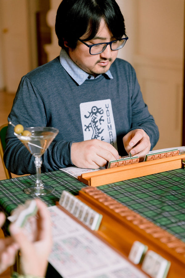 A player studying the hands on the mahjong card